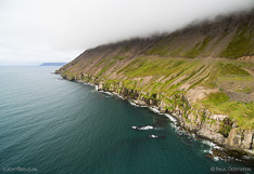 Coastline in Ólafsfjörður in northern Iceland, with mountain in the clouds. Aerial photo captured with a camera drone (Phantom).