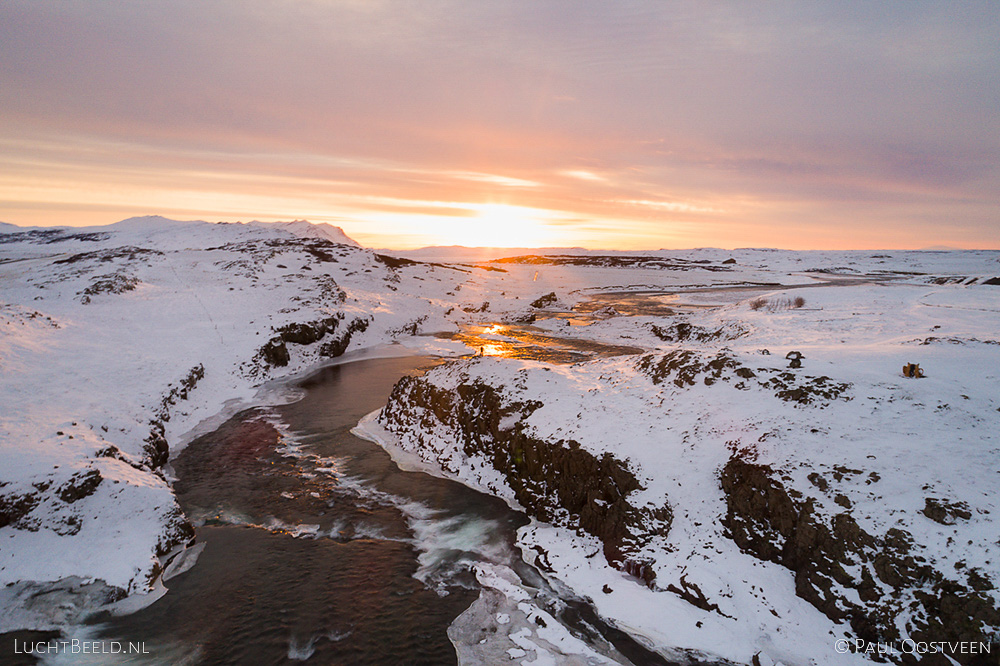 Sunset above a river and waterfall