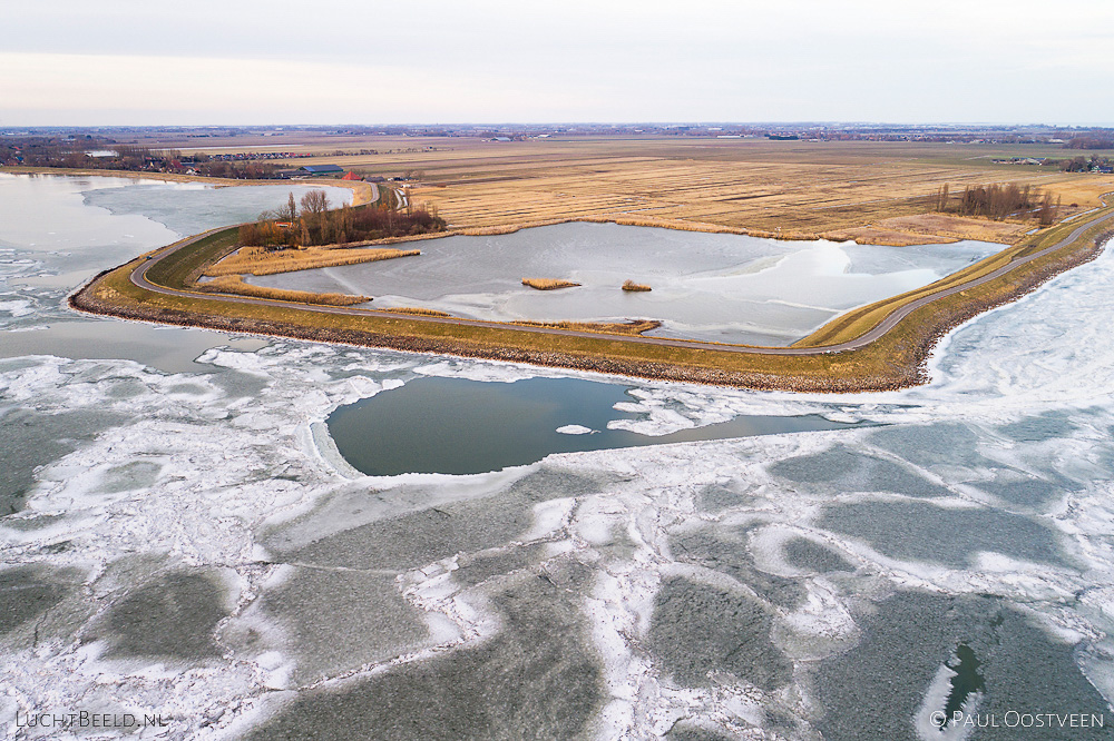 Bevroren Markermeer met achter de dijk natuurgebied De Nek. Luchtfoto gemaakt met een drone.