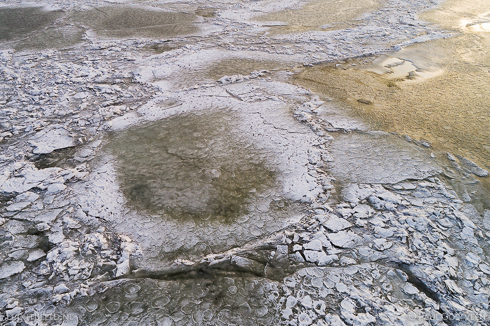 Kruiend ijs in het Markermeer met refelectie van de zon, gefotografeerd met een drone.