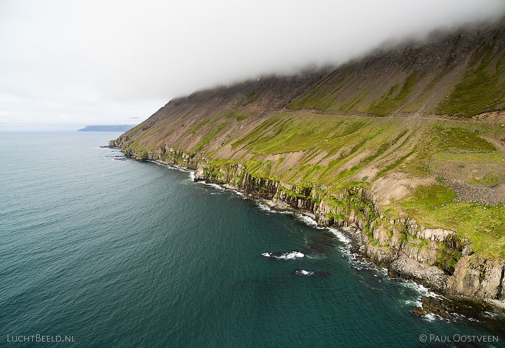 Coastline in Ólafsfjörður in northern Iceland, with mountain in the clouds. Aerial photo captured with a camera drone (Phantom).